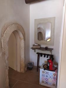 a hallway with a mirror and a table in a room at Wild Violet Villa: an old vision of luxury in Melidhónion