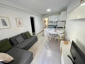 salon z kanapą i stołem w obiekcie La Pineda Holiday Apartment w mieście La Pineda