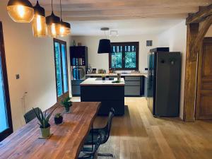 a kitchen with a wooden table and a refrigerator at Oak'Wood in La Queue-lès-Yvelines