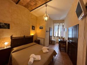 een slaapkamer met een bed met twee handdoeken erop bij Affittacamere Licenza N.1 Presso La Magica Torre in Pitigliano