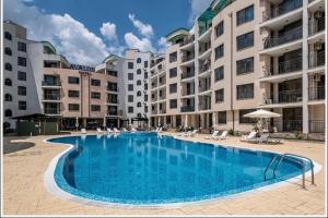 a large swimming pool in front of some apartment buildings at Hotel AVALON in Nesebar