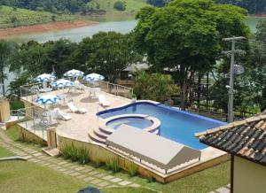 a large swimming pool with umbrellas and a pool at Recanto Apoena in Santa Isabel