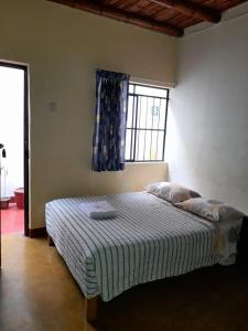 sypialnia z dużym łóżkiem i oknem w obiekcie Brabant Hostal w mieście Nazca