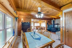 une salle à manger avec une table, des chaises et un ventilateur de plafond dans l'établissement Long Pond Camp, à Jefferson