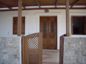 una puerta de madera frente a una casa en private beachfront house en Lefkos Karpathou