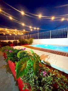 a swimming pool with plants next to a swimming pool at CasaBlanca ApartaEstudios in Girardot