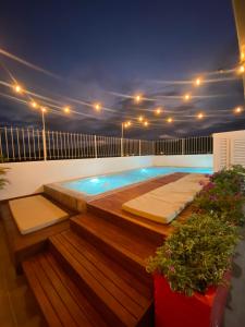 a swimming pool with two beds on a balcony at night at CasaBlanca ApartaEstudios in Girardot