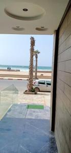 ein Gebäude mit einer Palme und einem Auto in der Unterkunft Appartement résidence Atlantic 1 in Kenitra