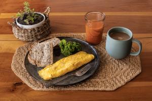 un plato de comida con brócoli y pan y una taza de café en Espacio Ecole Pucon, en Pucón