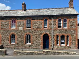 un viejo edificio de ladrillo con una puerta negra en Victorian Police Station - flexible suite, self contained en Launceston