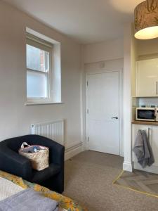 a living room with a blue chair and a door at Victorian Police Station - flexible suite, self contained in Launceston