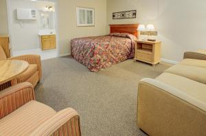 pokój hotelowy z łóżkiem, stołem i krzesłami w obiekcie Mountain Aire Inn Sevierville - Pigeon Forge w mieście Sevierville