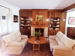 a living room with two white couches and a fireplace at Charming House with Pool & Barbecue in Valle de Abdalagís