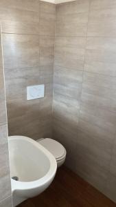 La salle de bains est pourvue de toilettes blanches et d'un lavabo. dans l'établissement Villa Alma, à Collepasso