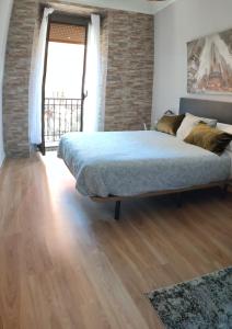 a bedroom with a bed and a brick wall at El Primero de Steven - Pegado a Playa de San Lorenzo in Gijón