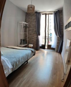 um quarto com uma cama e uma grande janela em El Primero de Steven - Pegado a Playa de San Lorenzo em Gijón