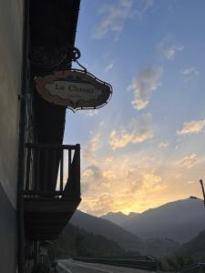 um sinal na lateral de um edifício ao lado de uma estrada em Locanda La Clusaz em Gignod