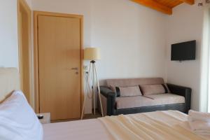 a bedroom with a bed and a couch and a television at Alex & Sofi Apartments in Himare