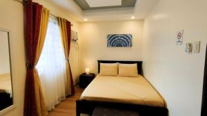 niewielka sypialnia z łóżkiem i oknem w obiekcie KASSFFER APARTMENT w Panglao City