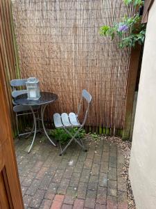 a table and two chairs next to a fence at Cobwebs in Kedington
