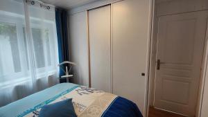 a bedroom with a bed and a large window at Le Petit Paradis in Brive-la-Gaillarde