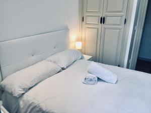 un letto bianco con due cuscini sopra di Central Market 2 habitaciones Parking opcional by Salamancavacacional a Salamanca