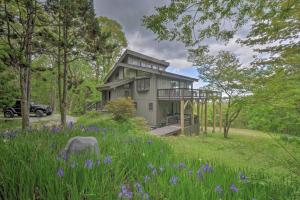 una casa en medio de un campo con flores púrpuras en Cabin with Balcony and Mtn Views Near Sky Valley!, en Dillard