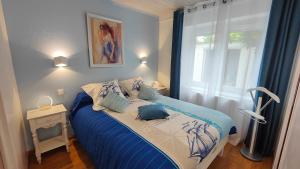 - une chambre avec un lit bleu et blanc et une fenêtre dans l'établissement Le Petit Paradis, à Brive-la-Gaillarde