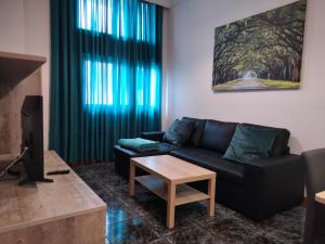 salon z czarną kanapą i stołem w obiekcie APARTAMENTOS La PEÑA A w mieście La Guancha