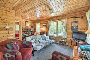 a living room with a couch and a tv at Waterfront Escape w/ Fire Pit in Crosslake! in Cross Lake