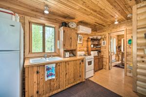 a kitchen with wooden cabinets and a white refrigerator at Waterfront Escape w/ Fire Pit in Crosslake! in Cross Lake