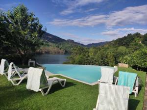 a group of chairs and a swimming pool at Eira House - Quinta de Fundevila in Vieira do Minho