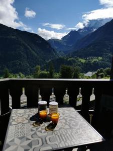 a table with two glasses of orange juice on a balcony at Apartment with balconies ski-in ski-out classified 2 stars in Saint-Gervais-les-Bains