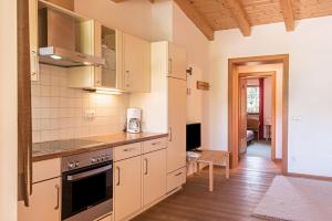 a kitchen with white cabinets and a wooden floor at Ferienparadies Sabina Zirbel in Alpe di Siusi