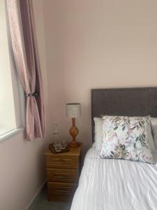 a bedroom with a bed and a lamp and a window at 29 The Square in Listowel