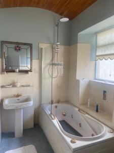 a bathroom with a bath tub and a sink at 29 The Square in Listowel