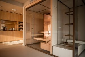 a glass walk in closet with a sink in it at Laguna Faro Suites - Adults Only & Free Beach in Grado