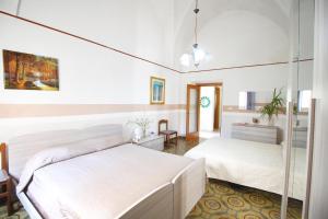 sypialnia z dwoma łóżkami i lustrem w obiekcie Casa Camoro a 150 mt dal mare w mieście San Foca