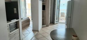 a kitchen with a table and a television in a room at Blue Bay Apartments in Syvota