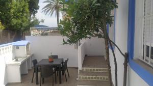 een patio met een tafel en stoelen en een boom bij La sirenita in Denia