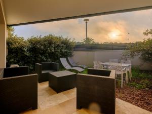 a patio with chairs and tables and a view at Résidence Les Suites Du Ferret in Cap-Ferret