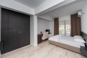 苏托莫雷N Hotel的一间卧室，配有一张床、一张书桌和一台电视