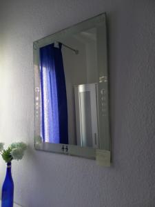 a mirror on a wall with a blue vase at habitación en el centro in Santa Cruz de Tenerife