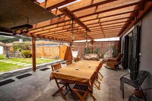 a patio with a table and chairs and a wooden ceiling at Casa da Porta Amarela in Sete Cidades