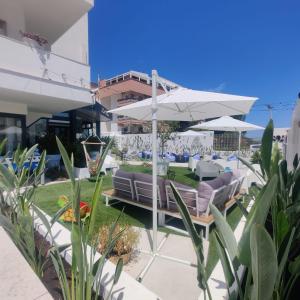 patio con divani e ombrellone di Hotel Riviera a Bari