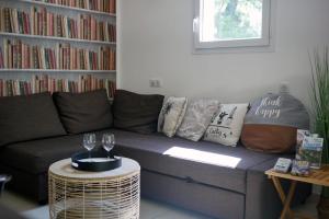 een woonkamer met een bank en een tafel met wijnglazen bij Gîte le Val Zen Valaurie - Drôme Provençale in Valaurie