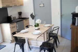 a kitchen with a wooden table with chairs and a dining room at Gîte le Val Zen Valaurie - Drôme Provençale in Valaurie