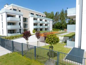 un edificio de apartamentos con jardín frente a él en Platinium Rewal Aparthotel 17 en Rewal