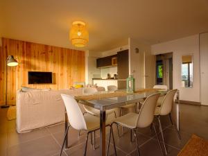 a dining room and living room with a table and chairs at Résidence Les Suites Du Ferret in Cap-Ferret