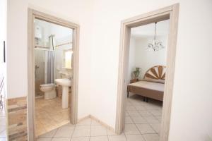 un bagno con un water, un lavandino e uno specchio di Casa Simone by RENTHOUSESALENTO a San Foca